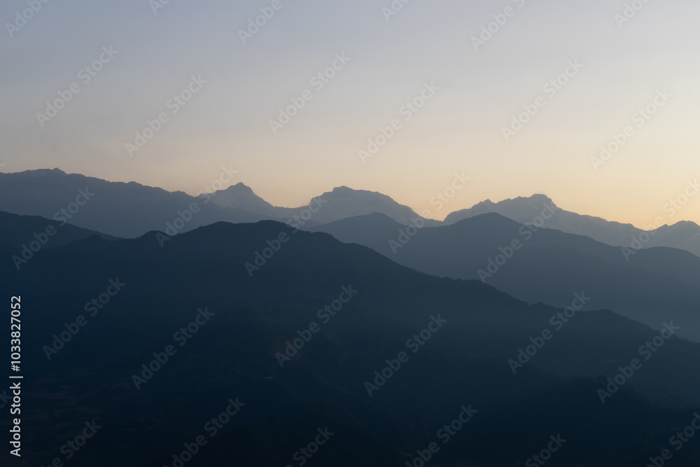 A serene view of mountain ranges at dusk. A serene view of mountain ranges at dusk.