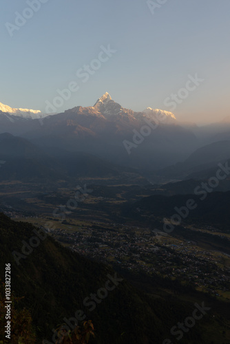 A stunning view of a mountain at sunrise with a town nestled in the valley below.