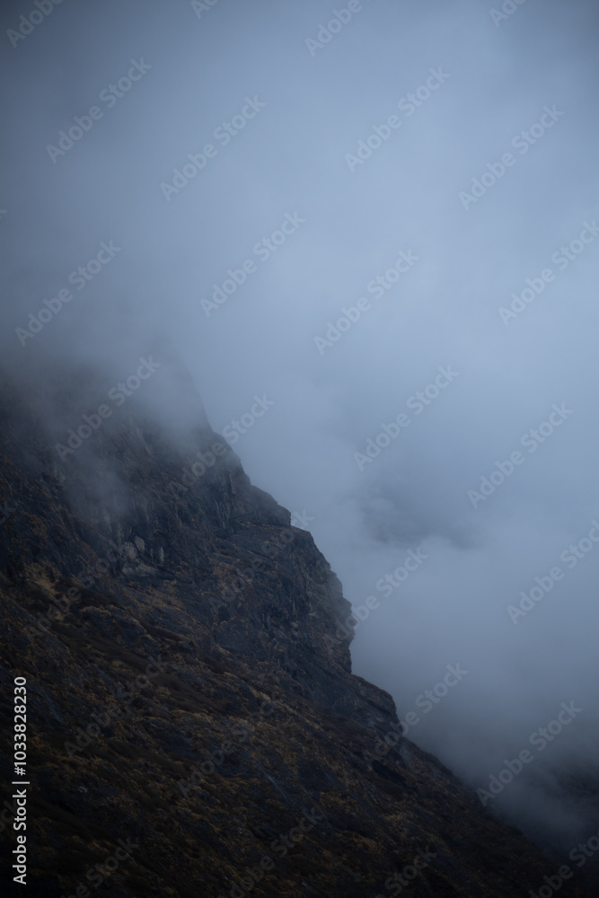 A misty mountainous landscape shrouded in fog. A misty mountainous landscape shrouded in fog.
