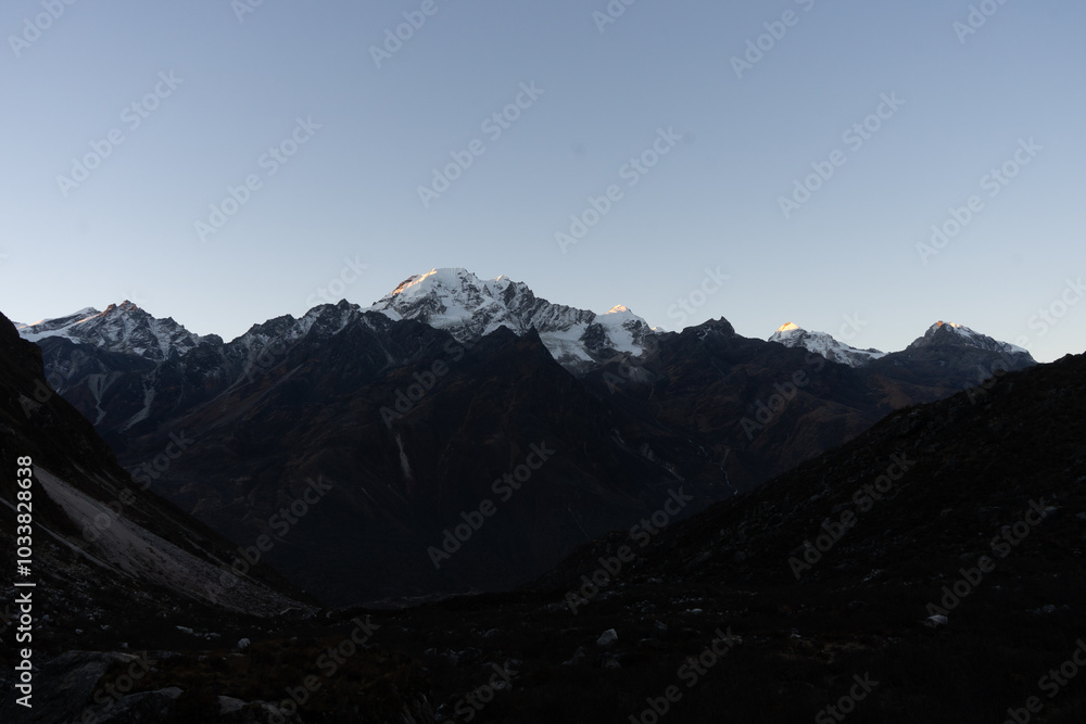 A serene view of snow-capped mountains during twilight. A serene view of snow-capped mountains during twilight.