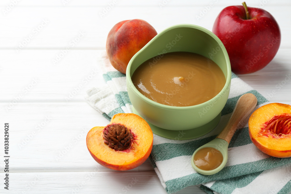 Delicious baby food in bowl and ingredients on white wooden table. Space for text Delicious baby food in bowl and ingredients on white wooden table. Space for text