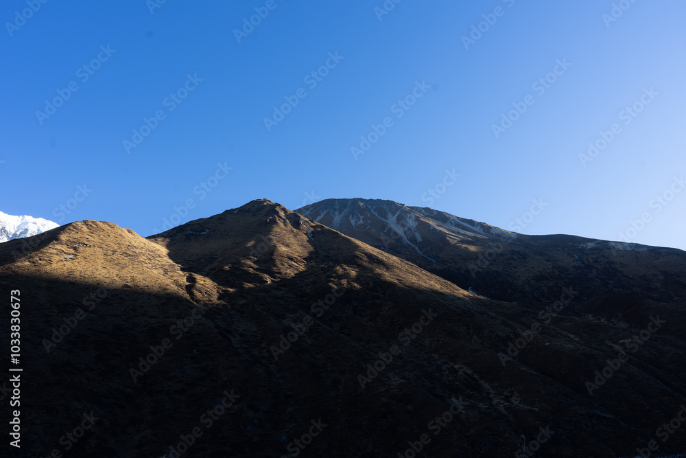 A stunning view of rugged mountains under a clear blue sky. A stunning view of rugged mountains under a clear blue sky.