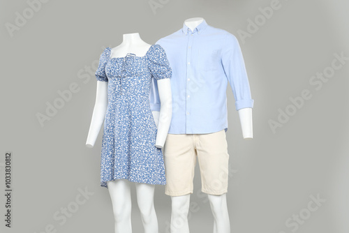 Female and male mannequins with stylish outfits on light grey background