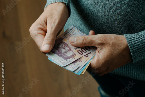 man counts some hungarian forint banknotes