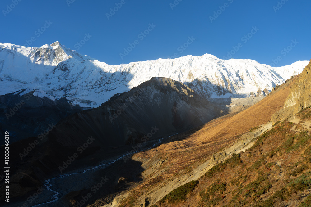 Fototapeta premium A stunning view of snow-capped mountains under a clear blue sky.