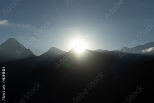 A breathtaking view of the sun rising over a mountain range, casting a serene glow. photo