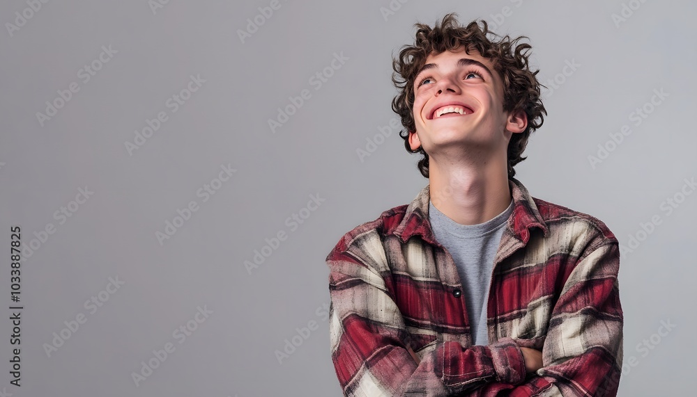 Smiling Young Man Looking Up with Crossed Arms Smiling Young Man Looking Up with Crossed Arms