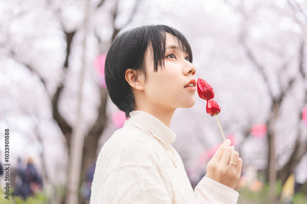 Side view asian woman eating japanese style street food strawberry candy japan tasty travel with sakura tree background Side view asian woman eating japanese style street food strawberry candy japan tasty travel with sakura tree background