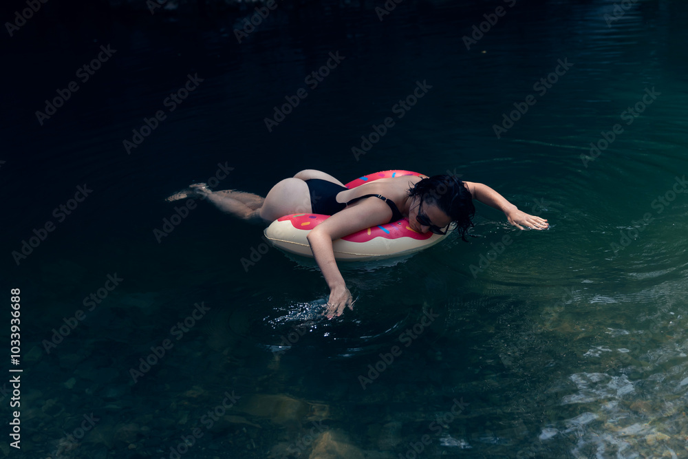 Woman Relaxing on Inflatable Float in Tranquil Natural Lagoon