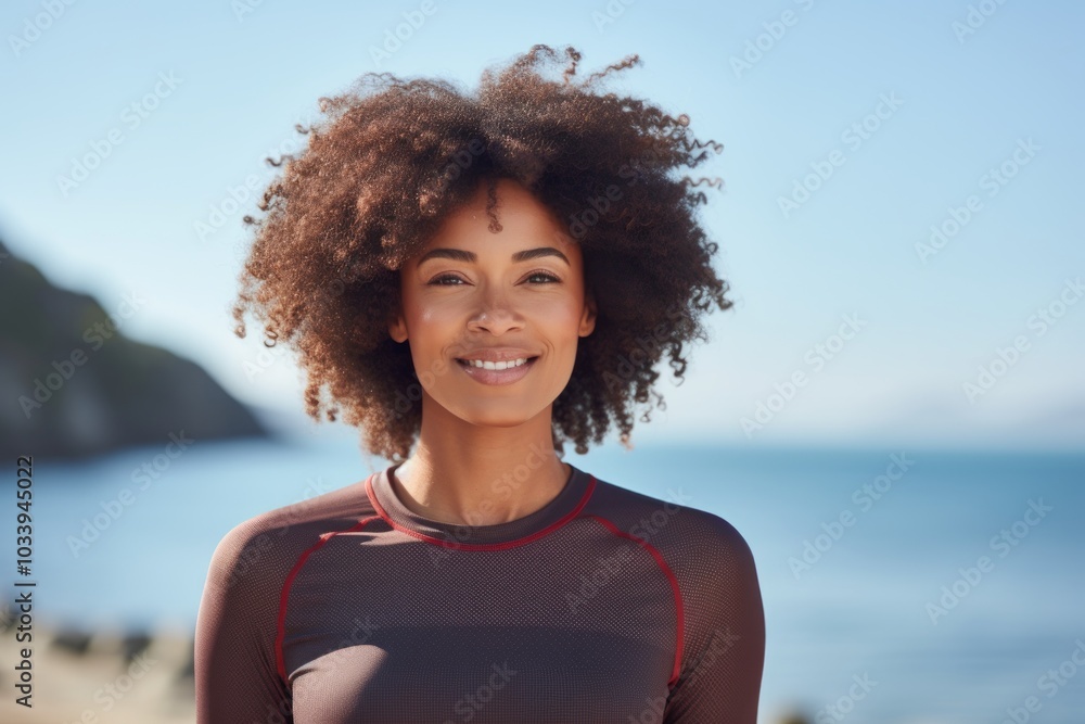 Portrait of a blissful afro-american woman in her 20s sporting a breathable mesh jersey over serene seaside background