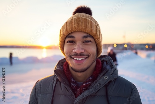 Portrait of a joyful afro-american man in his 20s dressed in a warm ski hat isolated on stunning sunset beach background