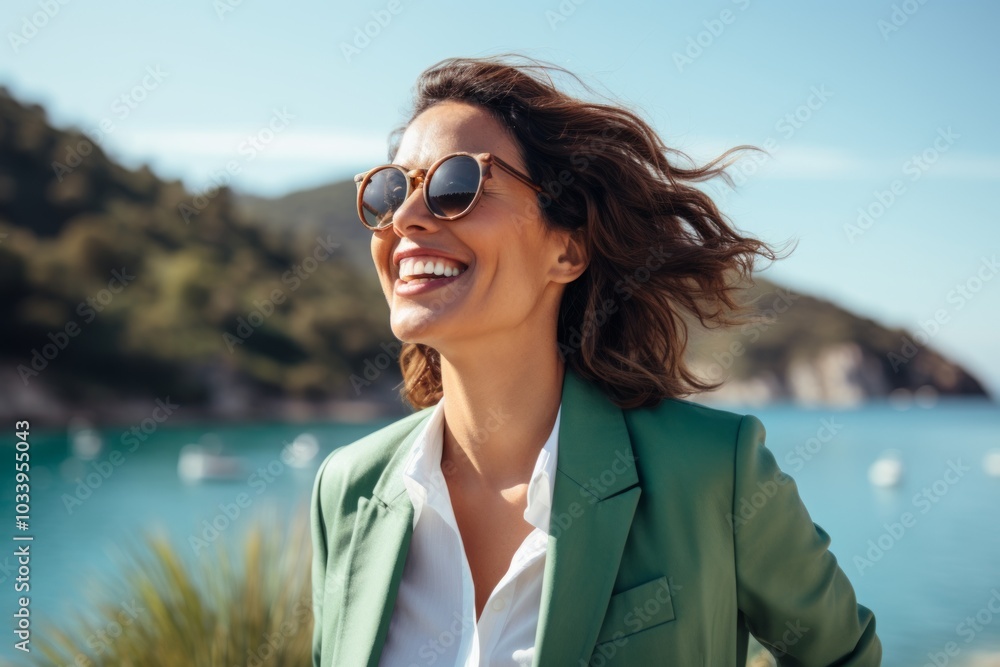 Portrait of a joyful woman in her 40s dressed in a stylish blazer in beautiful lagoon background Portrait of a joyful woman in her 40s dressed in a stylish blazer in beautiful lagoon background
