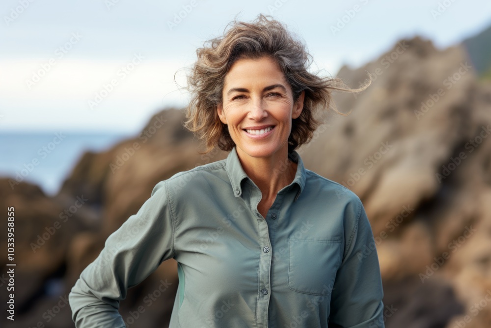 Portrait of a glad woman in her 50s sporting a breathable hiking shirt on rocky shoreline background Portrait of a glad woman in her 50s sporting a breathable hiking shirt on rocky shoreline background