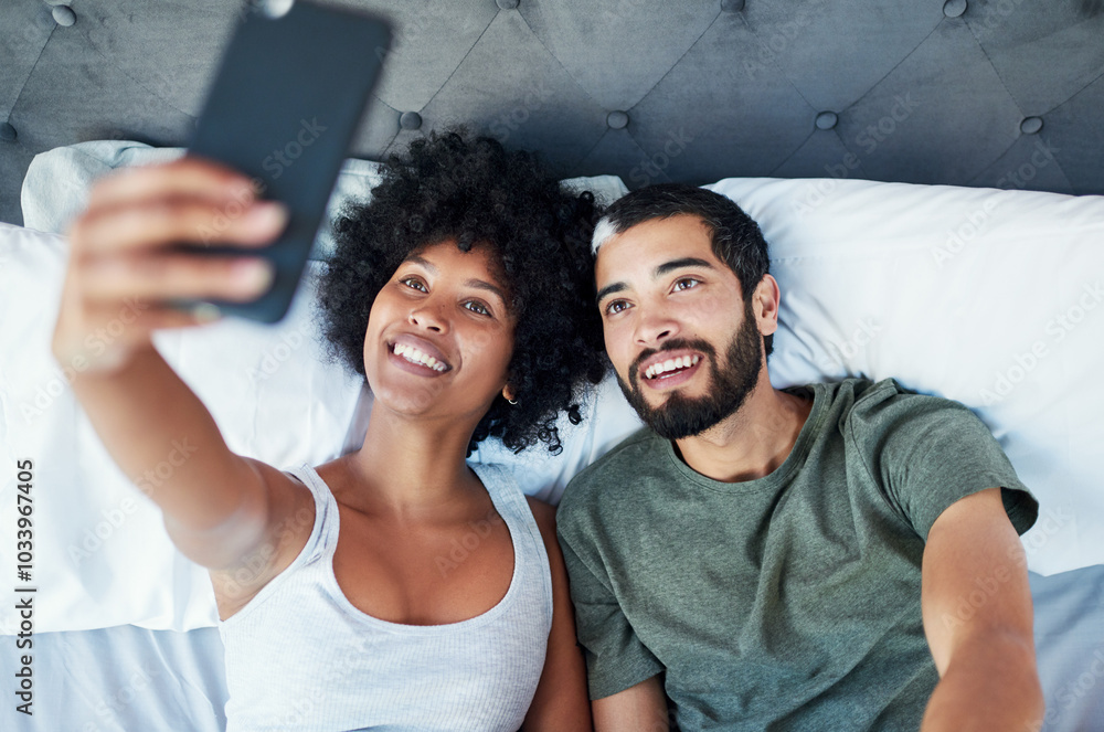 Fototapeta premium Couple, smile and love in bed with selfie to relax, break and memories at home in Brazil. People, relationship and above in bedroom to rest for social media, post or profile picture for bonding