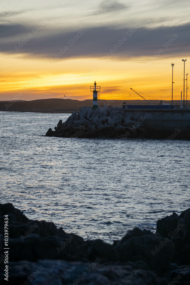Aatardecer en el Puerto de Camarones, en la Patagonia Argentina, provincia de Chubut, donde se puede apreciar el característico faro. Aatardecer en el Puerto de Camarones, en la Patagonia Argentina, provincia de Chubut, donde se puede apreciar el característico faro.