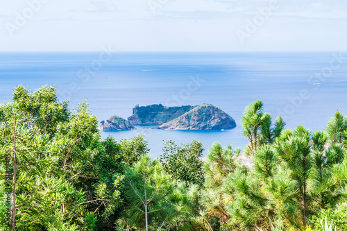 A view towards the islet of Vila Franca do Campo from the Chapel of Our Lady of Peace across Ribeira Seca on the island of San Miguel in the Azores in summertime photo