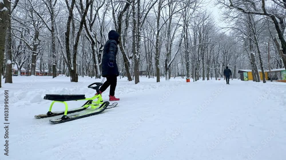 Snowmobile Rear View Rear view of mother with little son and child snowmobile in city park ...