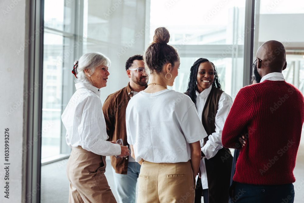 © Jacob Lund - Diverse business colleagues engaging in conversation during a conference in a modern office setting
