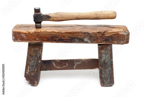 A hammer sits on top of a wooden bench, ready for use