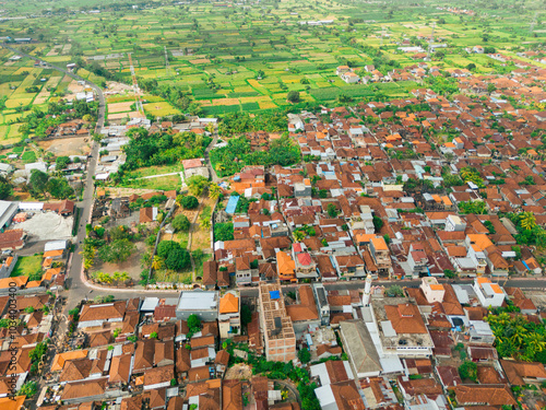 Aerial drone view of Muslim Balinese settlements near green paddy fields scenery at Gelgel Village in Klungkung, Bali, Indonesia. photo