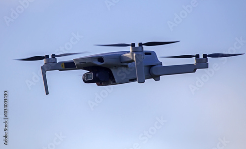 Drone flying in the sky. Radio-controlled quadcopter with a video camera for observing and filming nature.