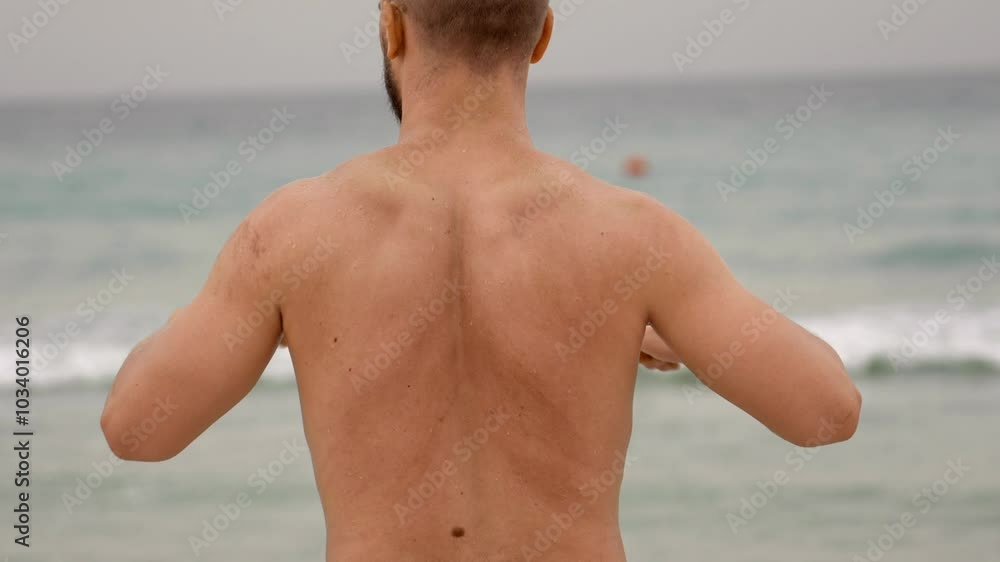 man treating posture on the seashore, back pain training man treating posture on the seashore, back pain training