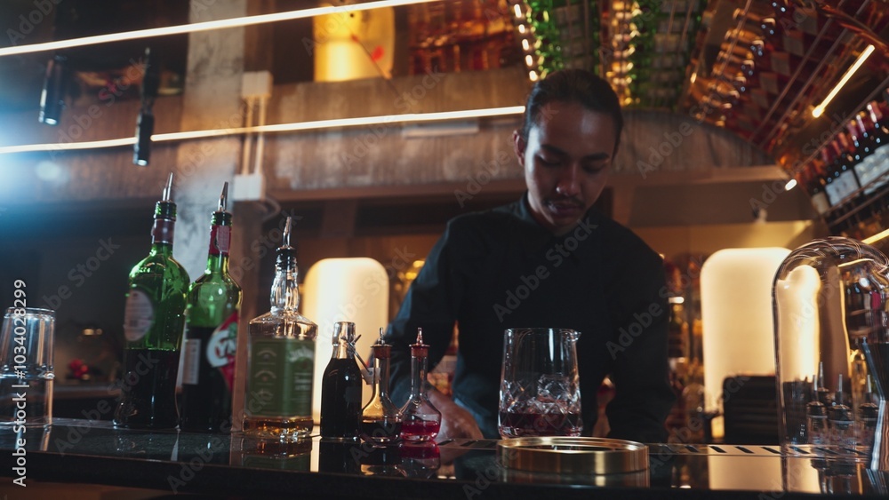 Portrait good looking Asian bartender using jigger measure liquor syrup into mixing glass preparation at luxurious beverage counter bar, neat professional barman costume at nightclub luxury. Vinosity. Portrait good looking Asian bartender using jigger measure liquor syrup into mixing glass preparation at luxurious beverage counter bar, neat professional barman costume at nightclub luxury. Vinosity.