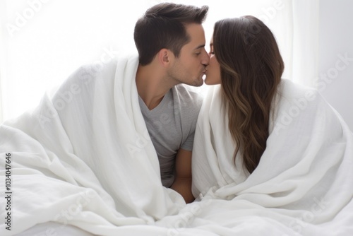 Hispanic couple kissing under the blanket adult affectionate togetherness.