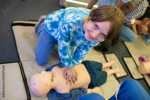 First aid training for a little boy on a CPR dummy. A boy learns first aid for a little boy in a workshop at school. .	
