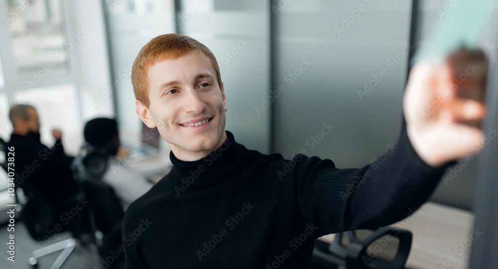 Red-Haired Caucasian Man Taking Selfie in Modern Office Environment Red-Haired Caucasian Man Taking Selfie in Modern Office Environment