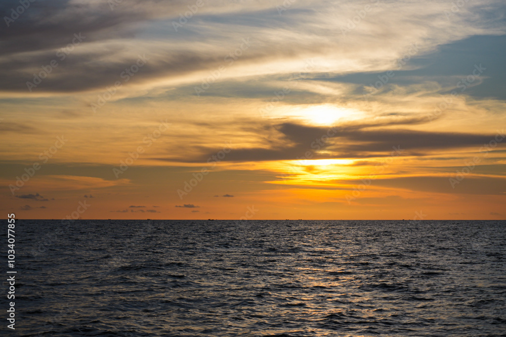 Beautiful sunset over the sea with vibrant colors reflecting on the water and clouds in the sky Beautiful sunset over the sea with vibrant colors reflecting on the water and clouds in the sky