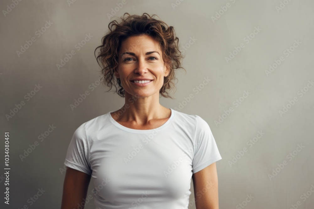 Portrait of a glad woman in her 40s sporting a breathable mesh jersey over minimalist or empty room background Portrait of a glad woman in her 40s sporting a breathable mesh jersey over minimalist or empty room background