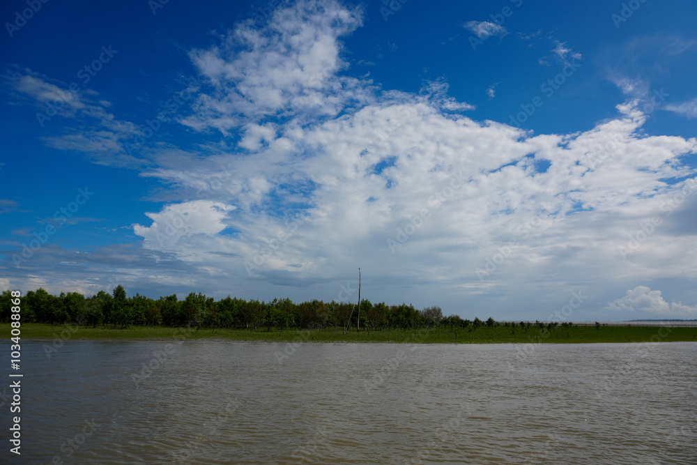 A serene landscape of clouds reflecting over a river and lake surrounded by lush green trees and a bright blue sky A serene landscape of clouds reflecting over a river and lake surrounded by lush green trees and a bright blue sky