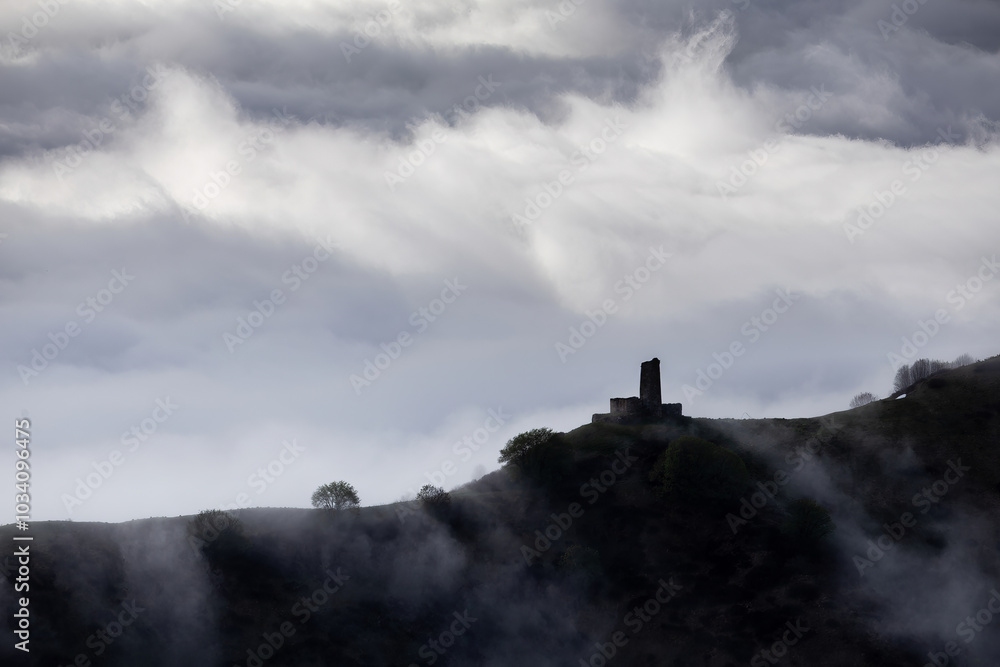 medieval tower on mountain above clouds, with snowy mountain picks, cloud flows over mountain ridge medieval tower on mountain above clouds, with snowy mountain picks, cloud flows over mountain ridge