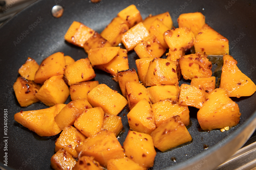 Diced butternut squash being cooked in a pan ready to be put in a dish Diced butternut squash being cooked in a pan ready to be put in a dish