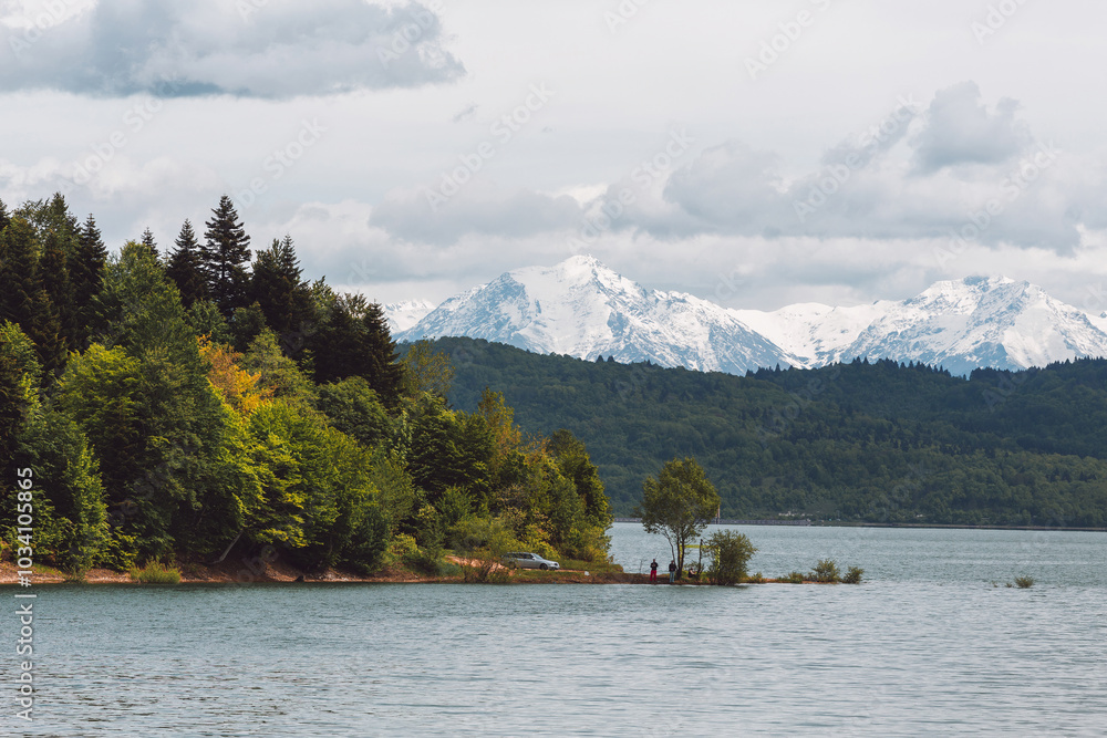 Mountain lake against the backdrop of snowy peaks, fishermen on the shore, Shaori Reservoir Georgia Mountain lake against the backdrop of snowy peaks, fishermen on the shore, Shaori Reservoir Georgia
