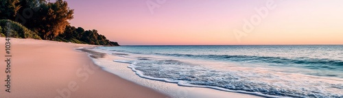 Serene beach at sunset with gentle waves lapping the shore, surrounded by lush greenery.