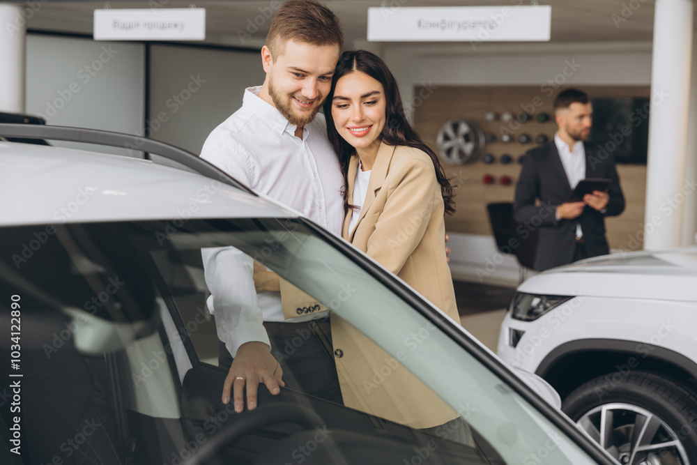 It is the one car I want! Beautiful young couple standing at the dealership choosing the car to buy It is the one car I want! Beautiful young couple standing at the dealership choosing the car to buy