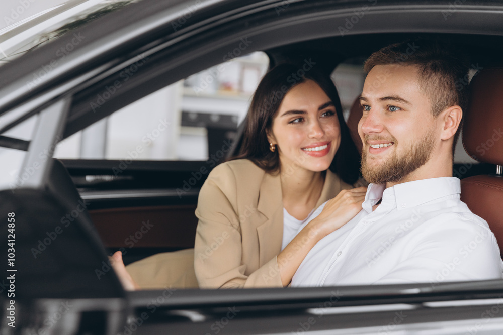 Portrait of smiling beautiful couple sitting in modern luxury car, happy excited young man and woman buying new car in dealership. Portrait of smiling beautiful couple sitting in modern luxury car, happy excited young man and woman buying new car in dealership.