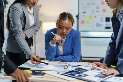 Team of business professionals are discussing over financial data on digital tablet and paperwork with charts and graphs