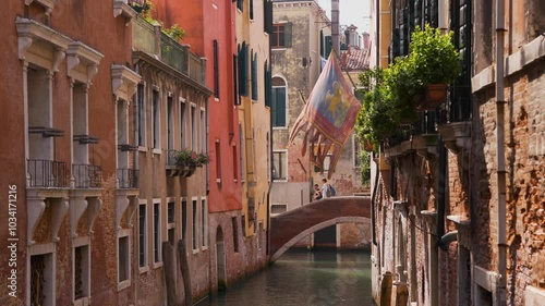 Venice Canal: Couple Walking Over Bridge with Flag - Sunny Day - Wide Shot