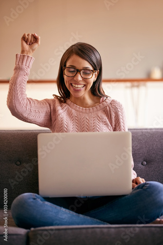 Excited, celebration and woman with laptop, win and cheering for victory, home and online competition. Notification, happy and person with joy, lottery and success in living room, fist and house photo