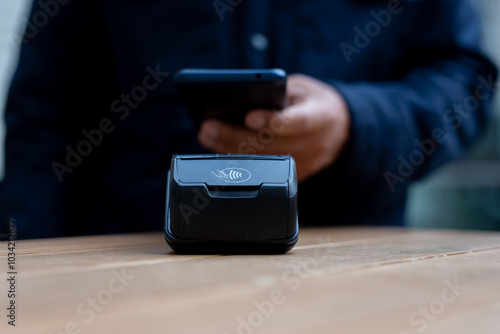 Customer using smartphone to make contactless payment in a cafe