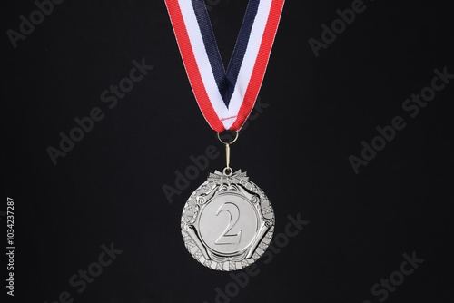 Silver medal with striped ribbon on black background