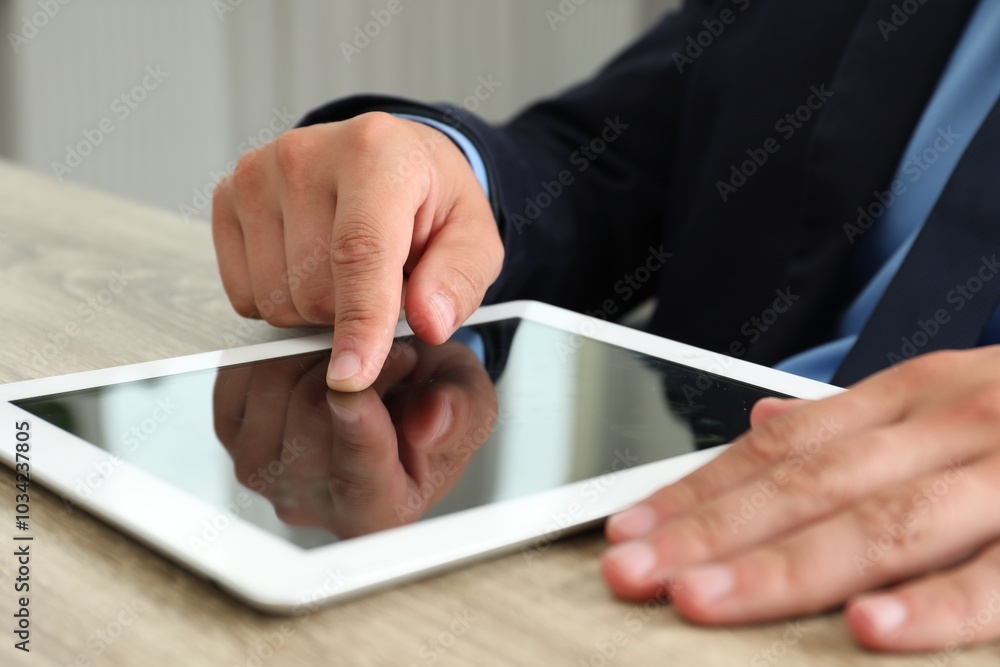 Businessman using tablet at wooden table, closeup. Modern technology Businessman using tablet at wooden table, closeup. Modern technology