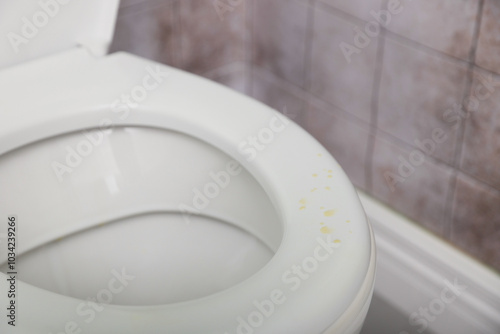 Urine drops on toilet seat in restroom, closeup