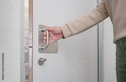 Foto Hand of an unrecognizable woman pulling the handle of the sliding door to open a