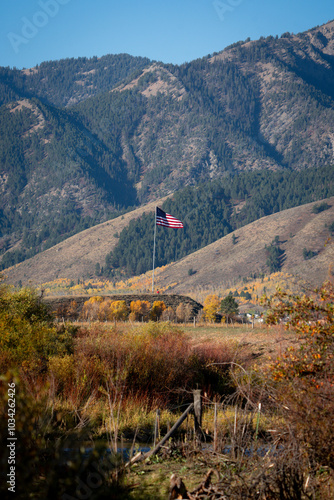 Photography American flag flying in pine covered Teton mountains of Wyoming in fall