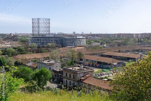 Panoramic view of the Ostiense district in Rome, with the famous Gasometer dominating the skyline. In the foreground, the former Mattatoio di Roma, built in the 19th century