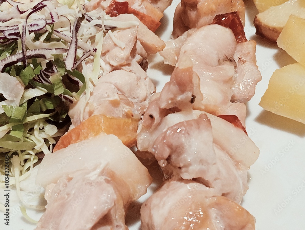 Italian dish with meat skewers, salad and baked potatoes